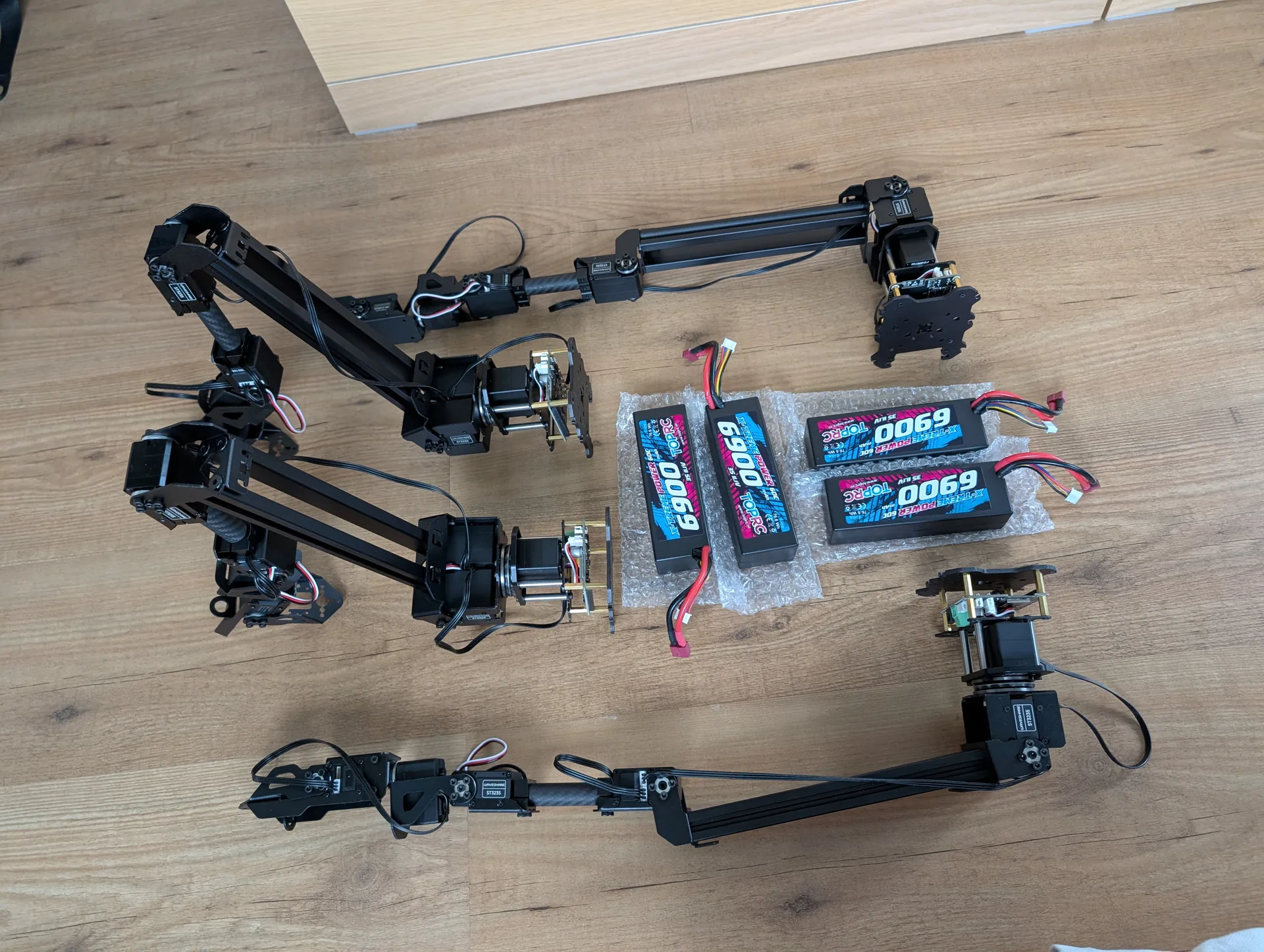 Gibbon Bot mk.2 limb assemblies and Li-Po batteries laid out for assembly